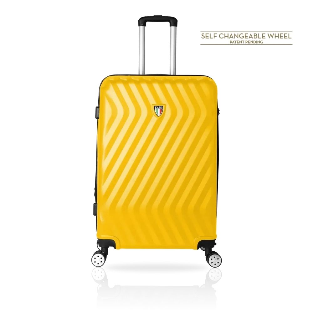 A bright yellow hardshell suitcase with a textured diagonal stripe pattern, an extended silver telescopic handle, and four spinner wheels. The brand shield logo is visible on the front.